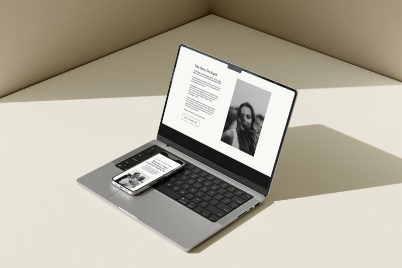 A minimalist Showit About Page template displayed on a laptop and smartphone. The screen shows a black-and-white portrait, a clean text layout introducing the user as “Aspen,” and a call-to-action button. The design features a neutral color palette and modern typography.